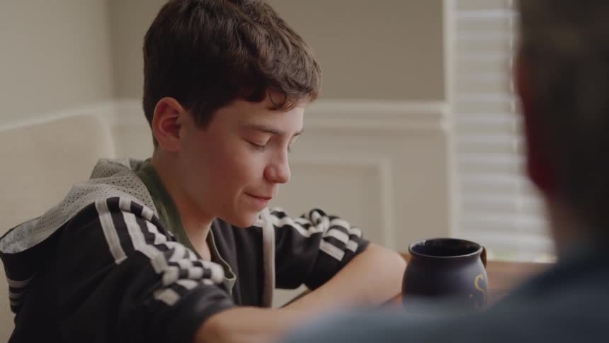 A woman and young boy sit together at a table