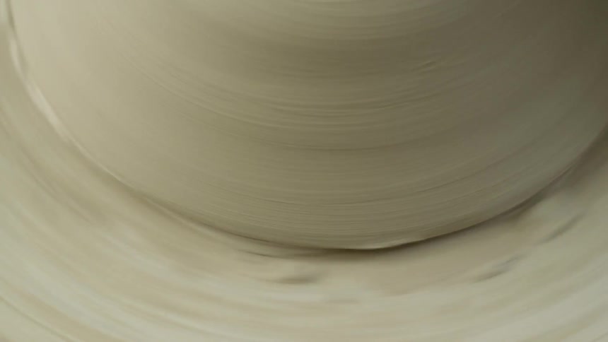 A large lump of clap spins on a pottery machine