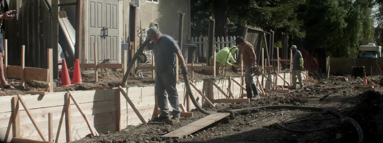 The workers are building a small wooden wall together