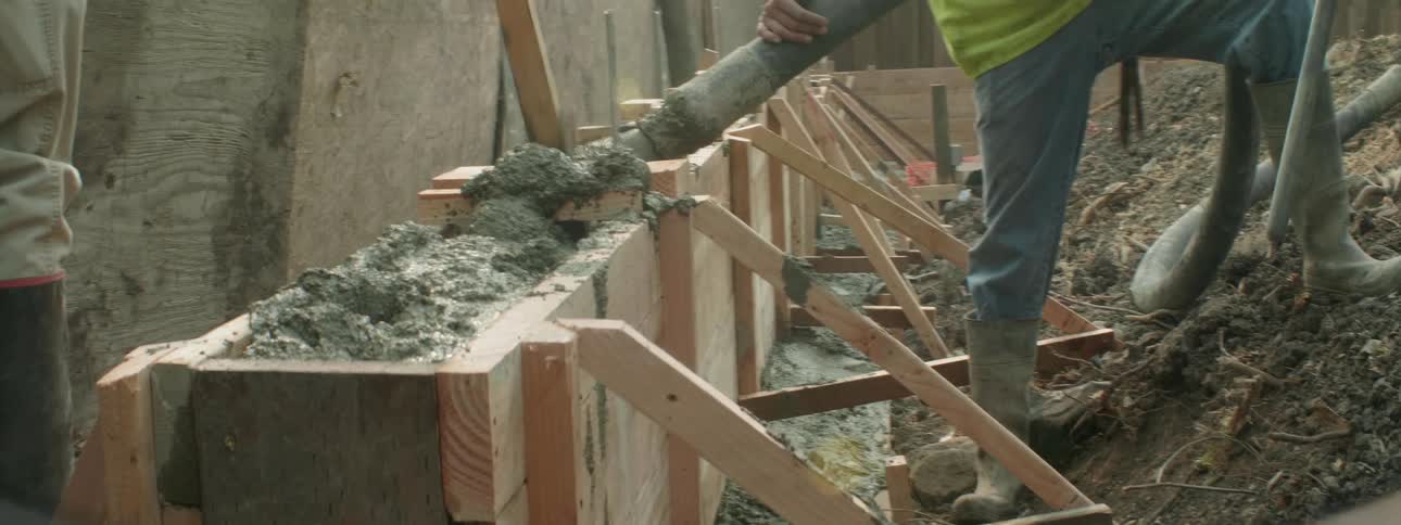 Construction workers lay concrete at a job site