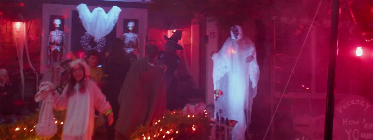 Kids trick or treat at a decorated house on halloween