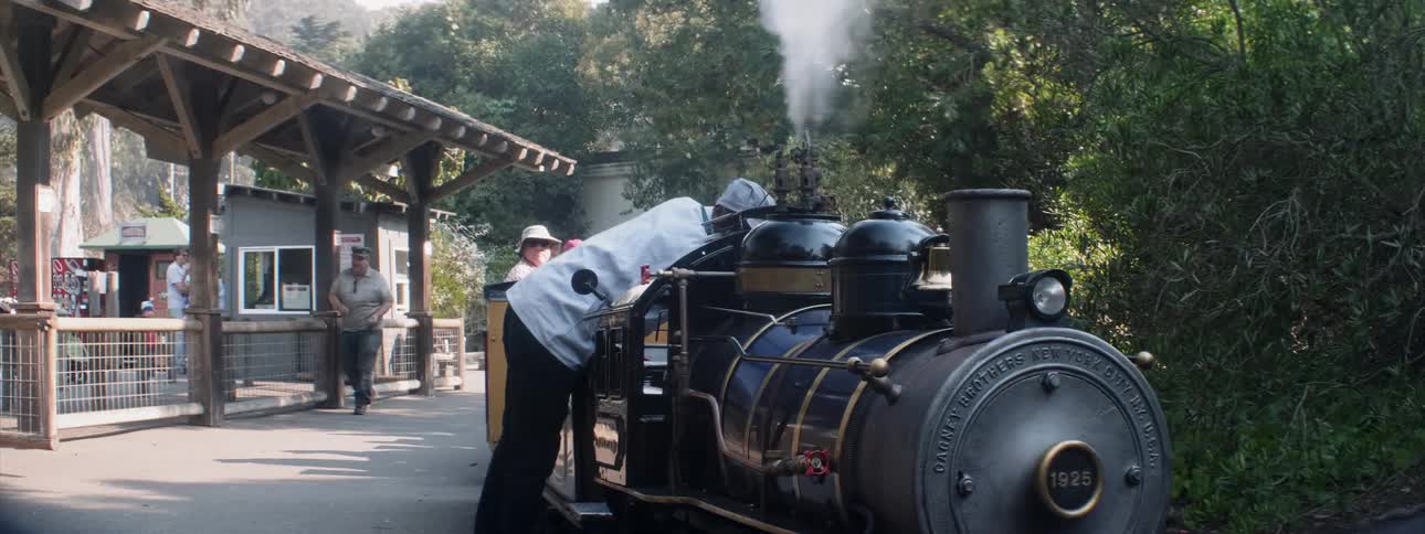 Man examines small steam locomotive