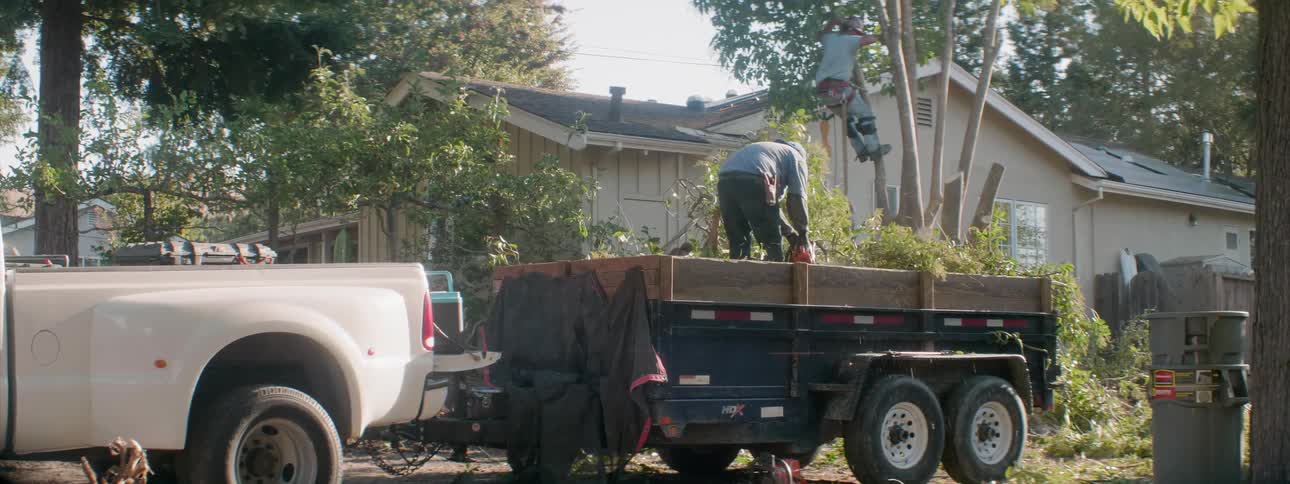 The landscapers are working in the yard on a sunny day
