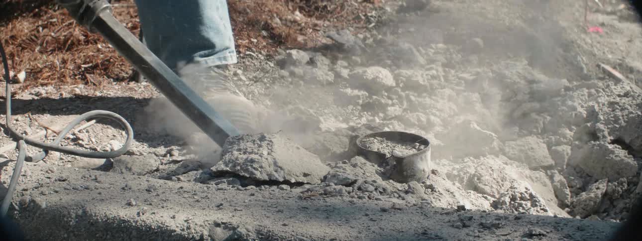 A person is using a jackhammer to break up concrete