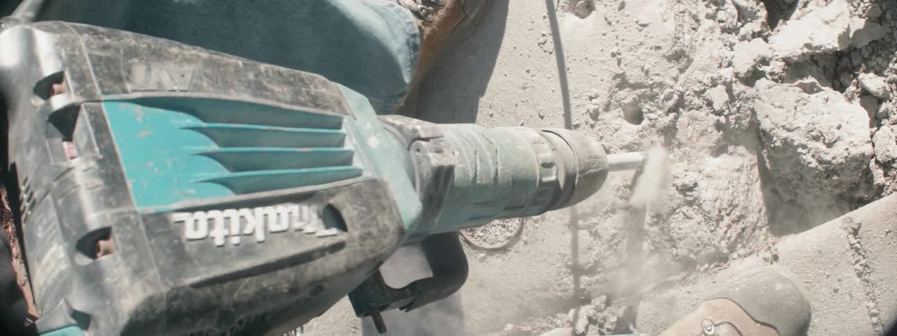 A construction worker uses a jackhammer