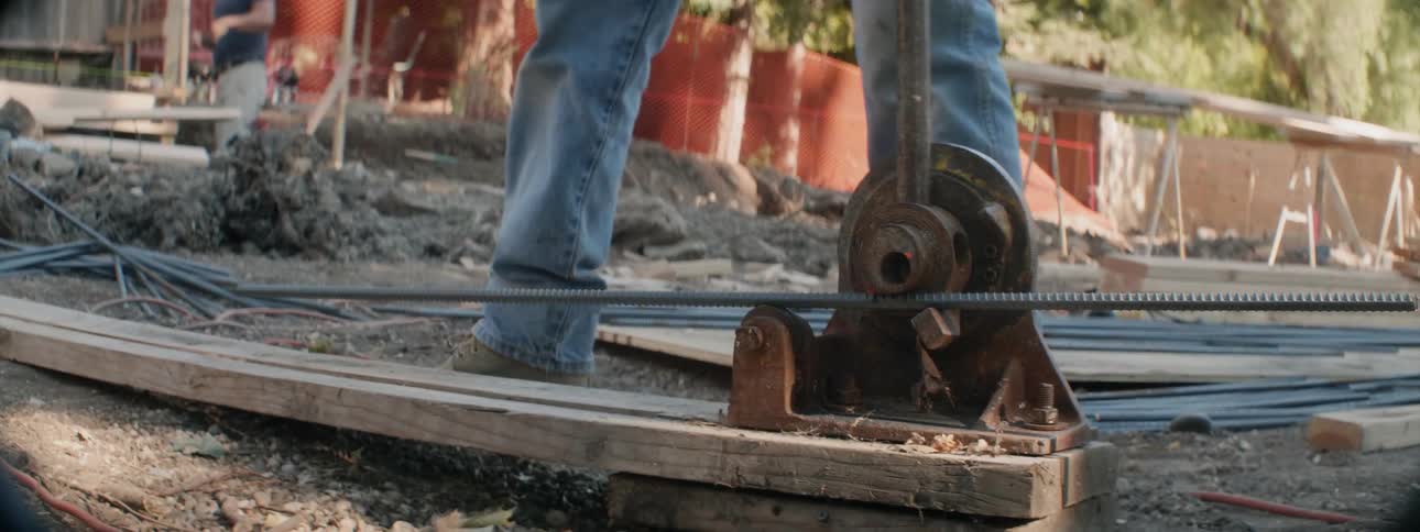 A construction worker bends metal at a job site