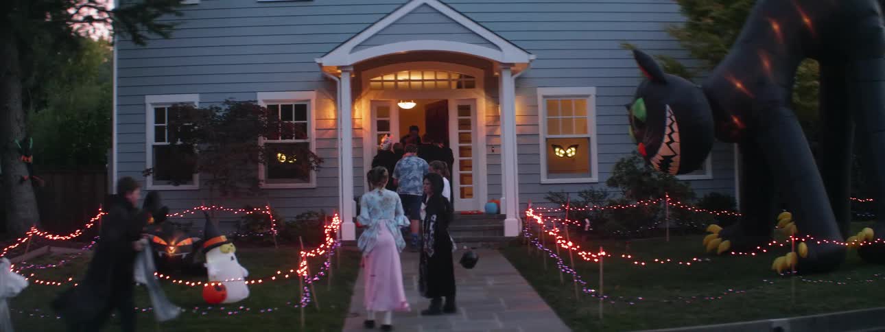 Trick or treaters line up in front of a house