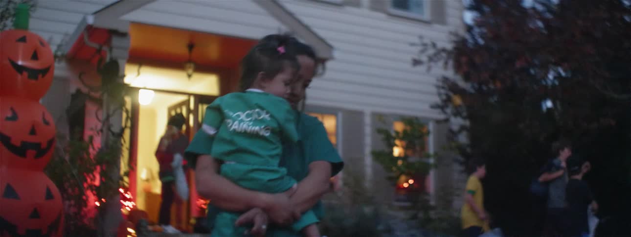 Children in costumes with parents walk around to homes on halloween