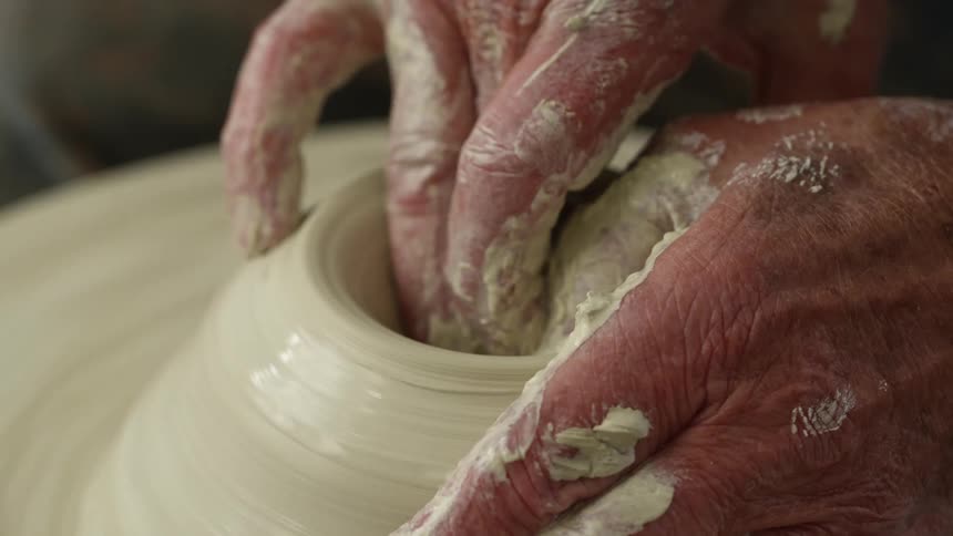 Man forming a bowl with clay