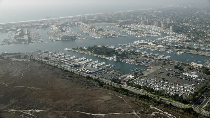 Boats float docked in a marina on a smoggy day