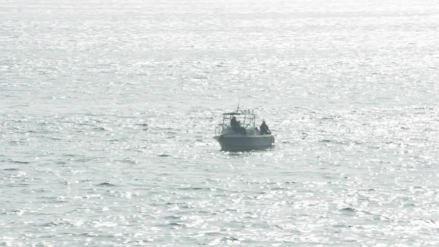 People fish from a boat on the ocean