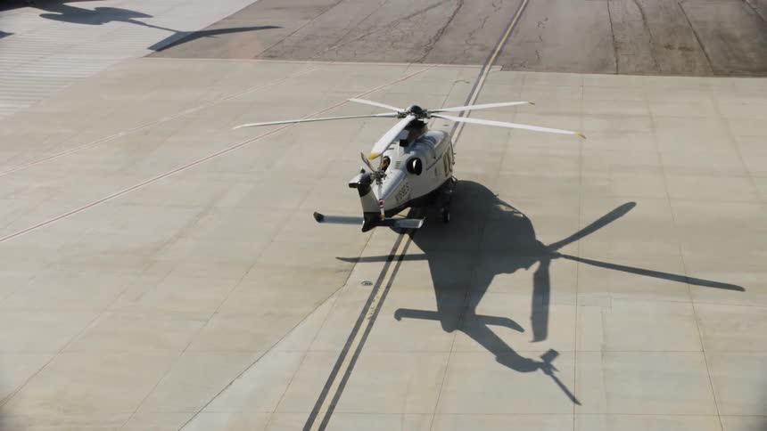 A helicopter is sitting idle on the runway