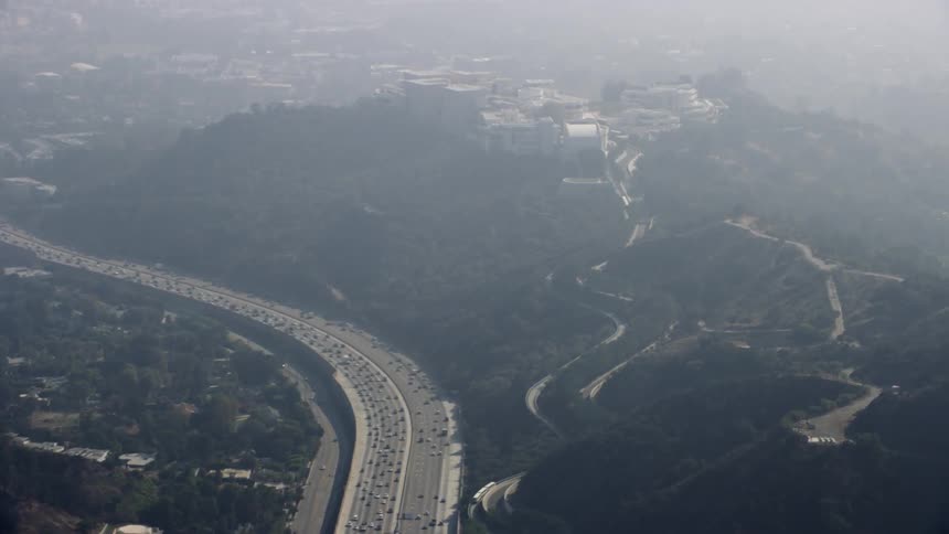 Building compound on a high hill near a large highway on a hazy day