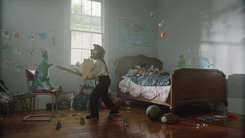 A young boy pretends to be a knight in his bedroom