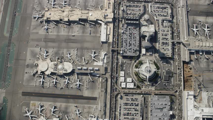 Cars drive around the large airport below