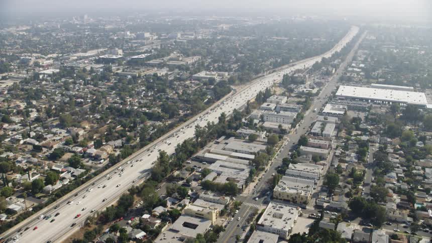 Highway going through a city with many vehicles traveling on it