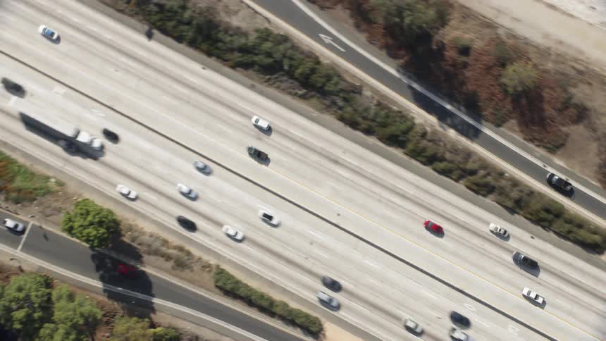 Cars drive fast on the highway below