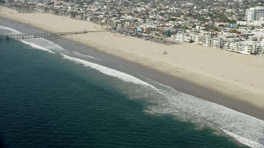Water splashing on the beach next to a city