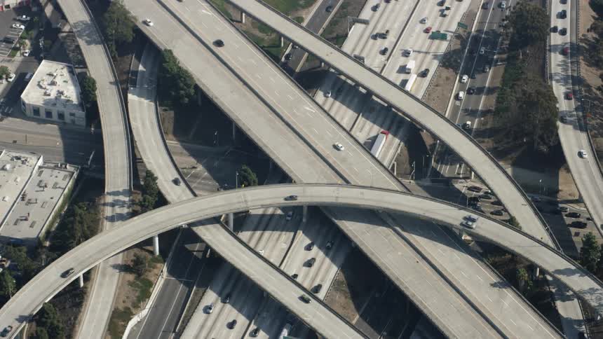 The cars drive on the road through the city below