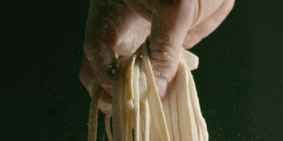 A person puts a pile of fresh pasta down