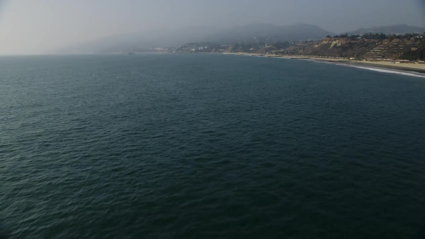 Smog and fog are lingering on a coastal area during the day