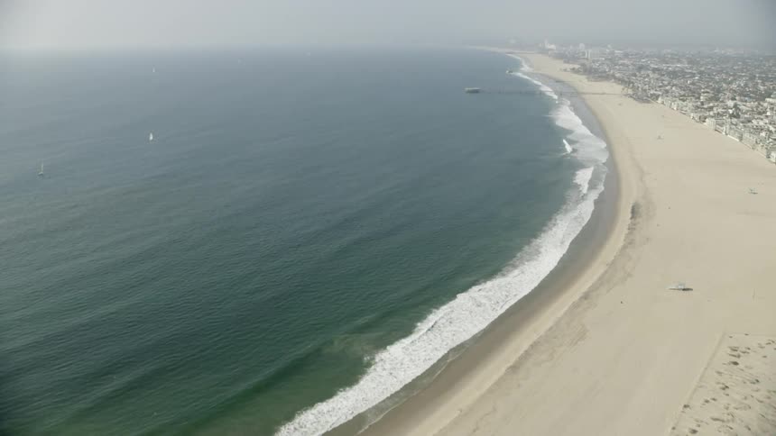 The waves crash against the shore of the coastal town