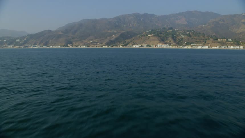 The blue water leads to the island with mountains ahead