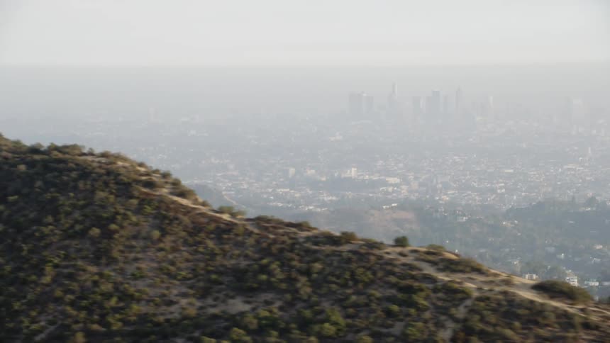 The tall hills lead to the city ahead on a foggy day