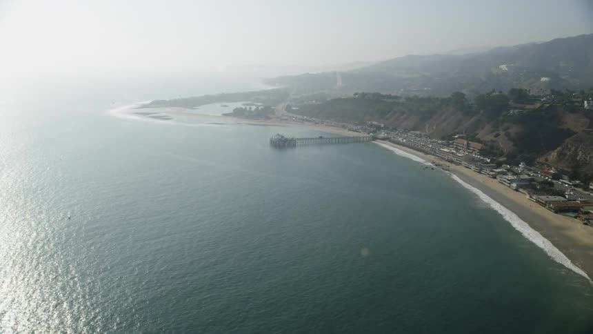 A pier runs out from the shore into the water ahead