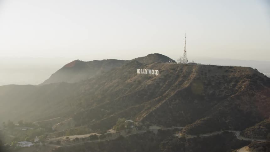 Smog is lingering on the hills below the hollywood sign during the day
