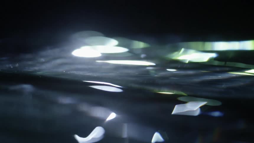 Light and shadow are reflecting in a body of moving water