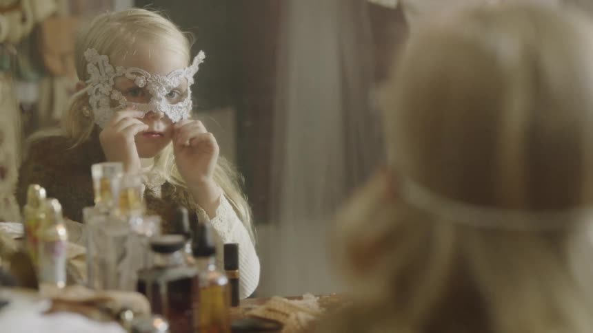 A young girl puts on a face mask at a vanity