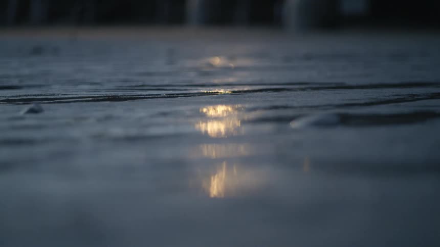 Light reflecting off of water streaming on the ground