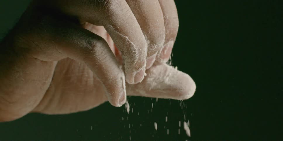 A person is rubbing and flicking the flour off their fingers