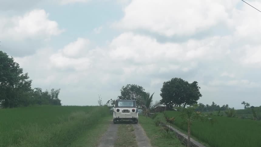 A vehicle drives in rural fields