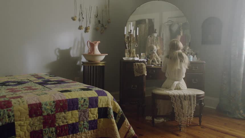 A child adjusts her mask in the mirror then walks off