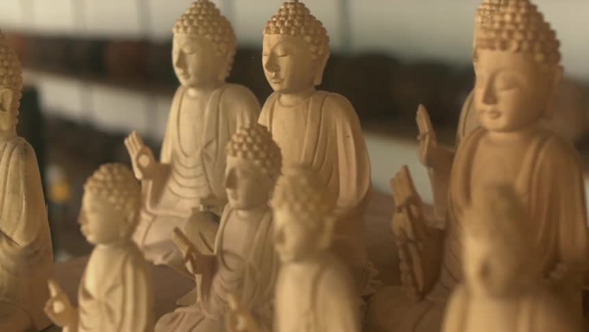 Buddha statues are lined up on a table