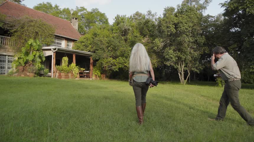 A man and woman are walking toward a home during the day