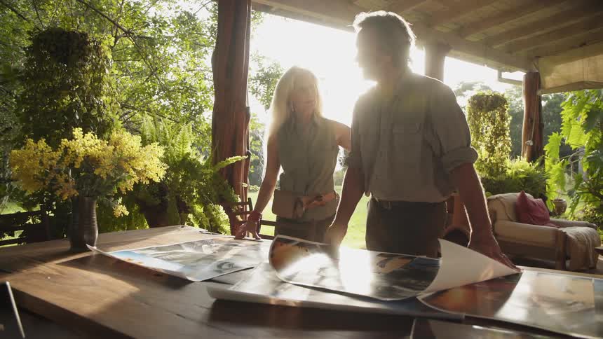 A man and woman talk while looking at photographs