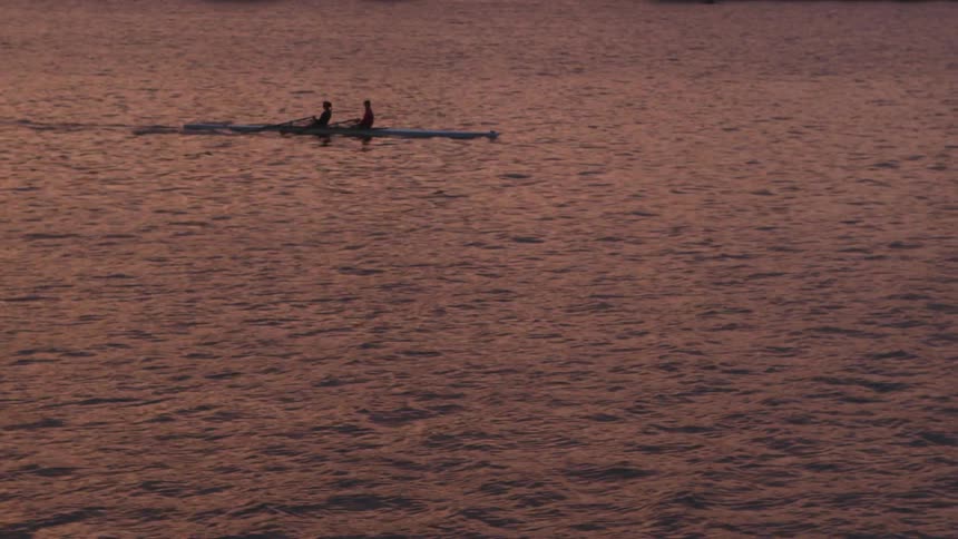 Two people rowing on a body of water