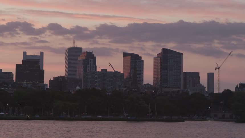 A city sits across the water at sunset