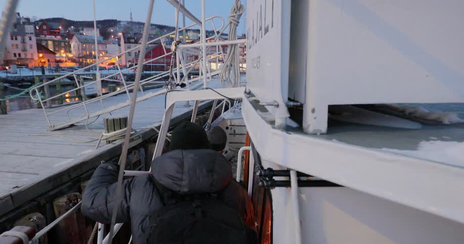 Two men walk onto a boat