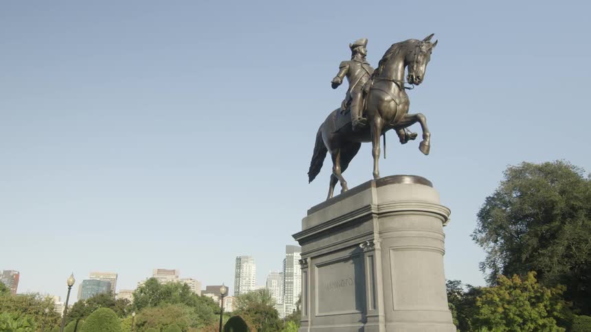 A statue sits before a city in the distance