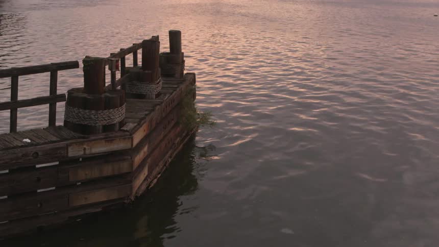 Water ripples towards a dock at sunset