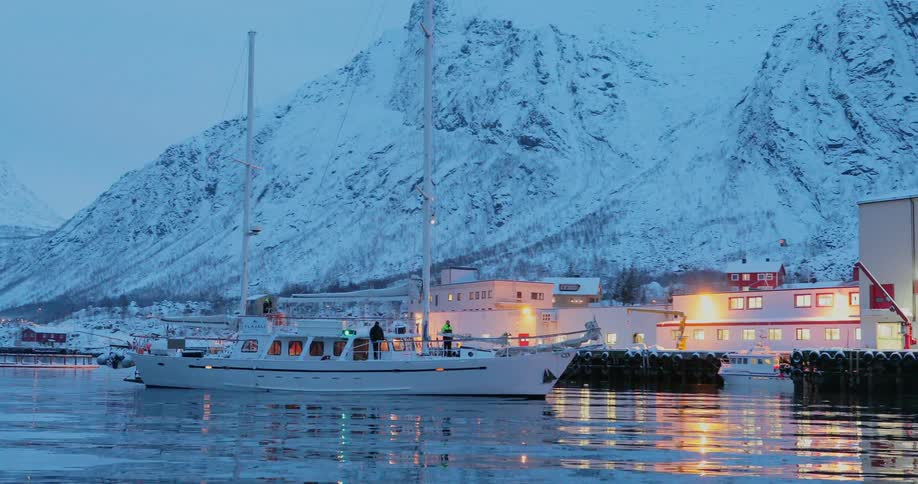 A boat travels on the icy waters at dusk
