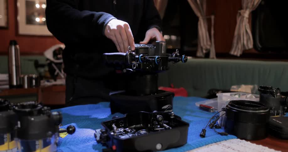 A photographer affixes attachments to a camera