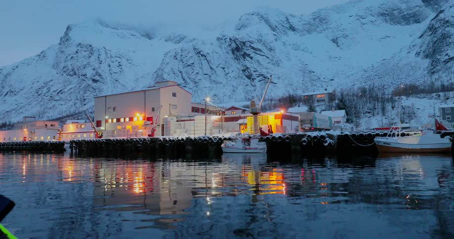 Building lights glow and reflect on the water