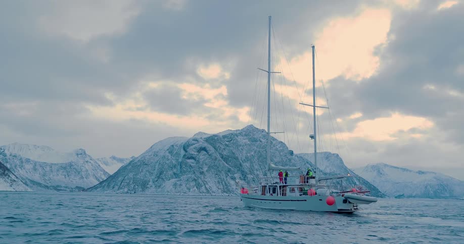 A boat floats off a snowy coast