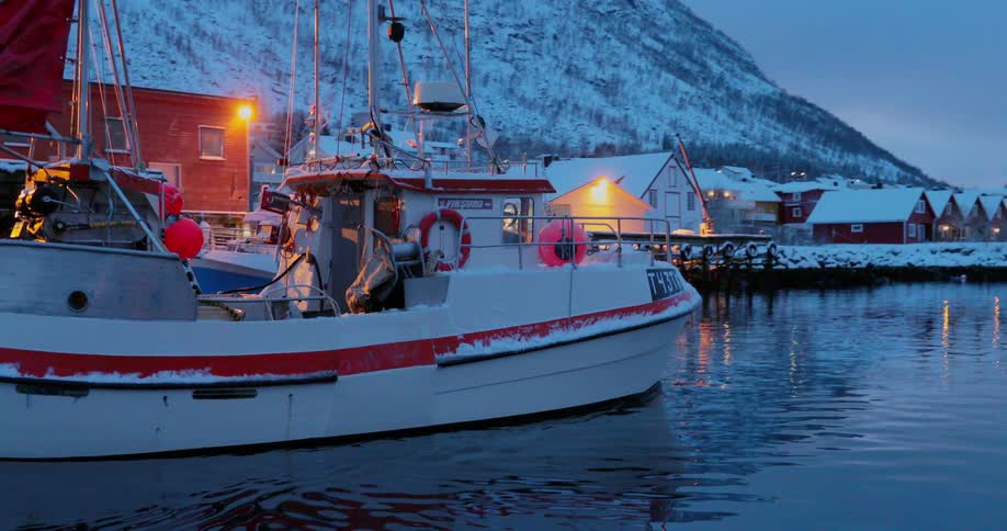 A boat travels on the icy waters at dusk