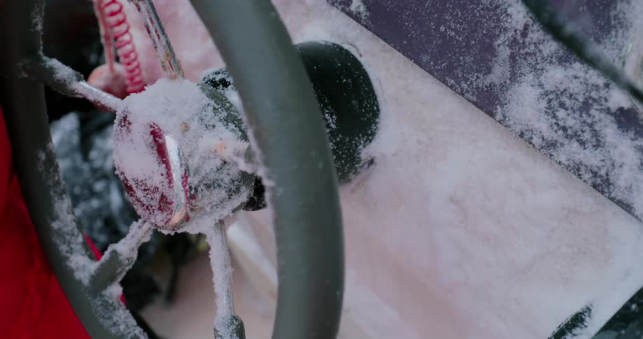 A ship's wheel is covered in snow